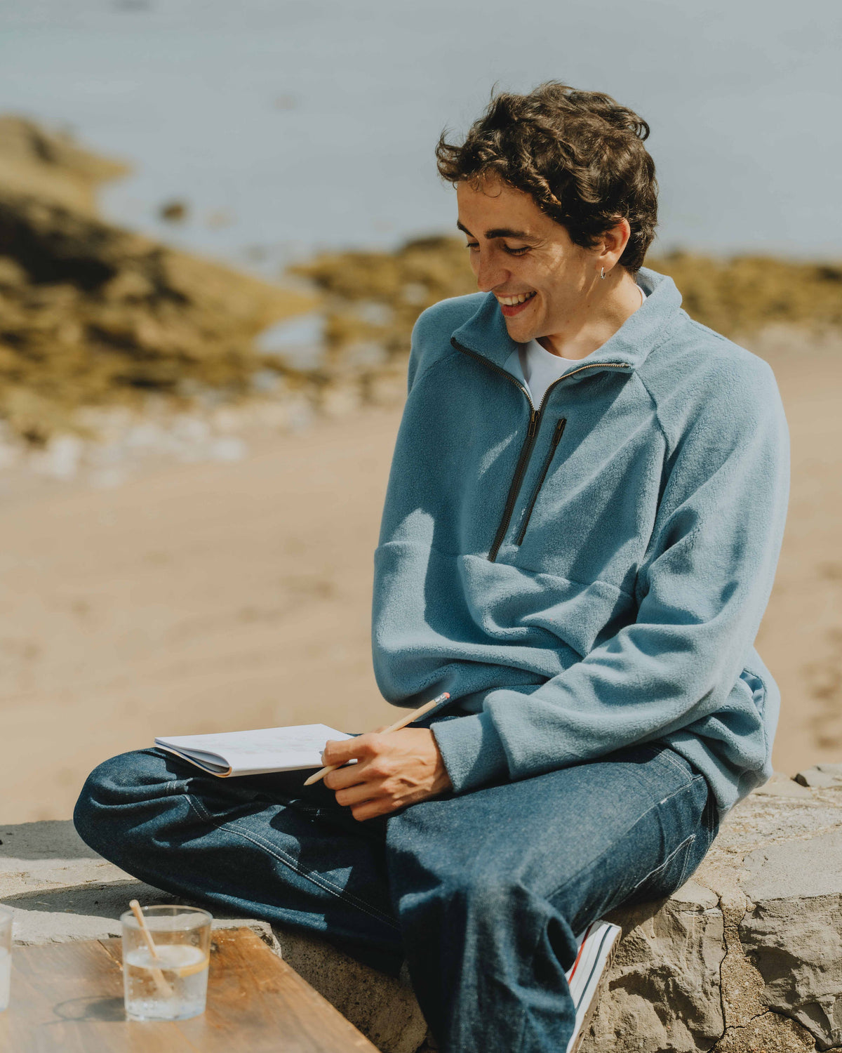 Patron de couture sweat homme Thomas avec col montant zippé, manches raglan et coupe confortable, porté en bord de mer