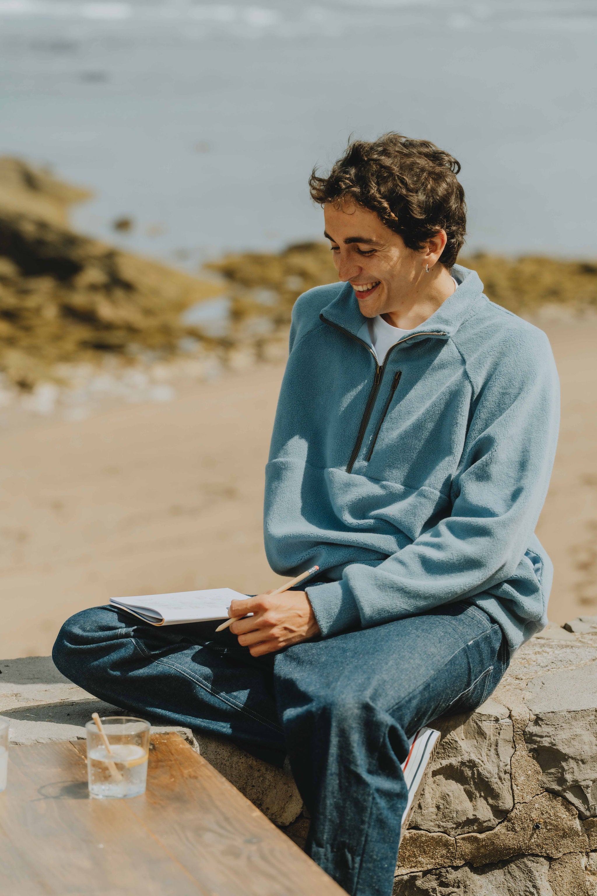 Patron de couture sweat homme Thomas avec col montant zippé, manches raglan et coupe confortable, porté en bord de mer